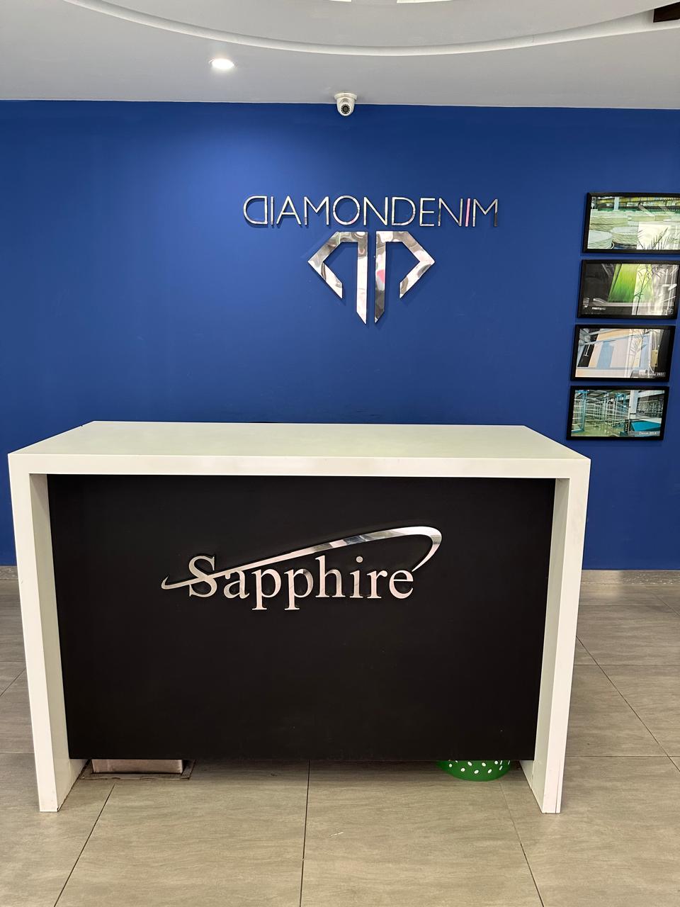 Diamond Denim by Sapphire reception — Diamondenim logo on blue wall with Sapphire branding